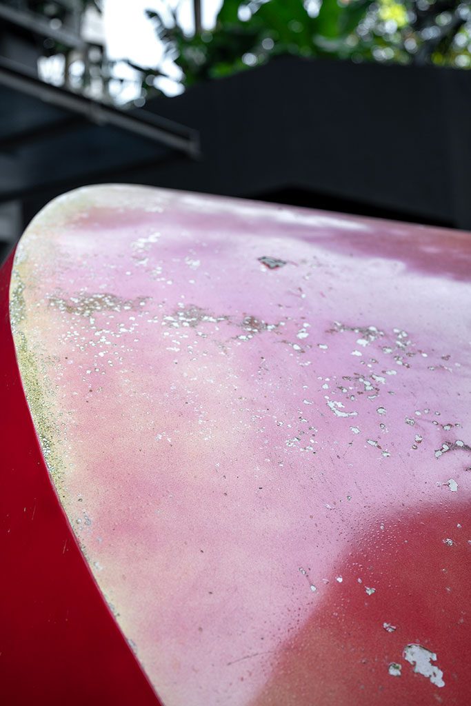 Before — close-up of flaking and faded pink surface